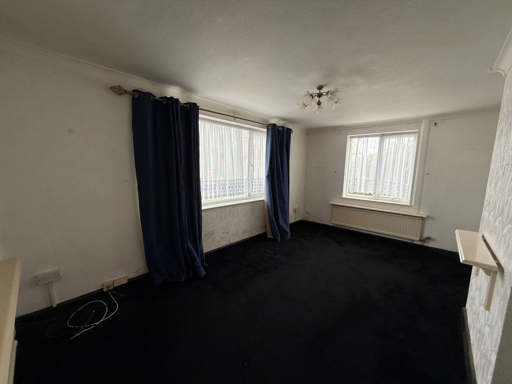 Lot: 163 - THREE-BEDROOM DETACHED HOUSE FOR IMPROVEMENT - Carpeted lounge with dual aspect windows and radiator